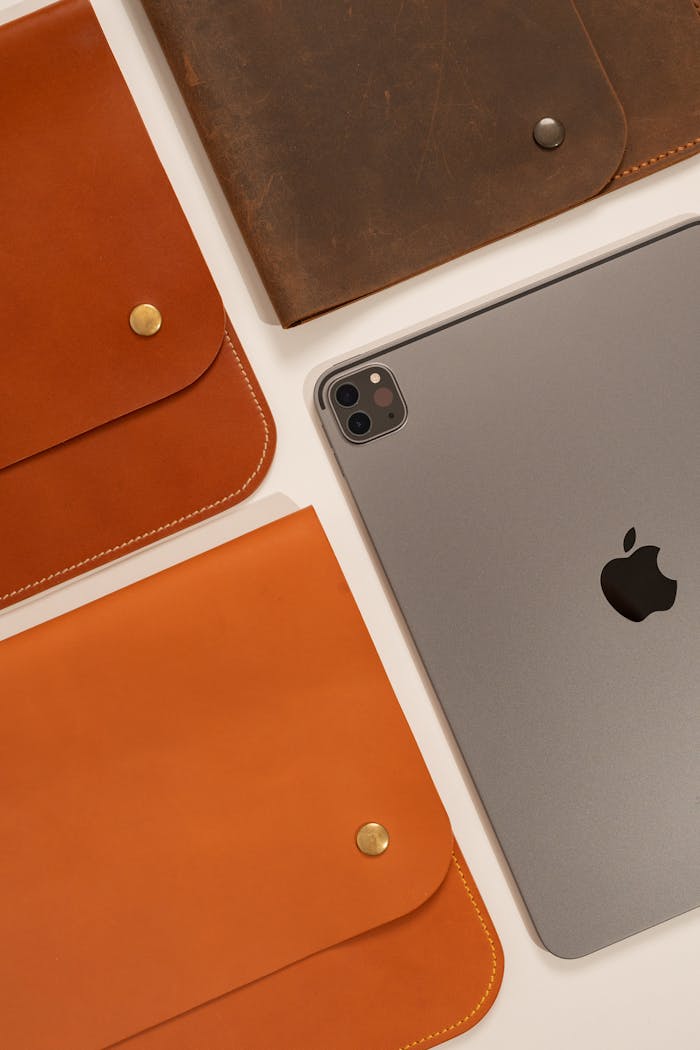 Elegant flat lay of Apple iPad with luxurious leather cases, showcasing modern technology and style.